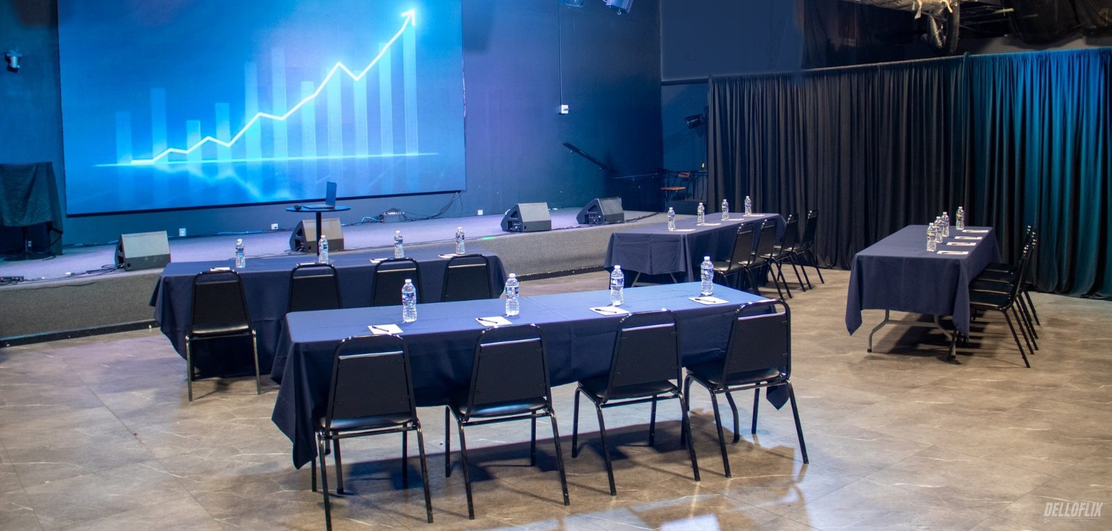 Conference layout with tables and a presentation screen at La Familia