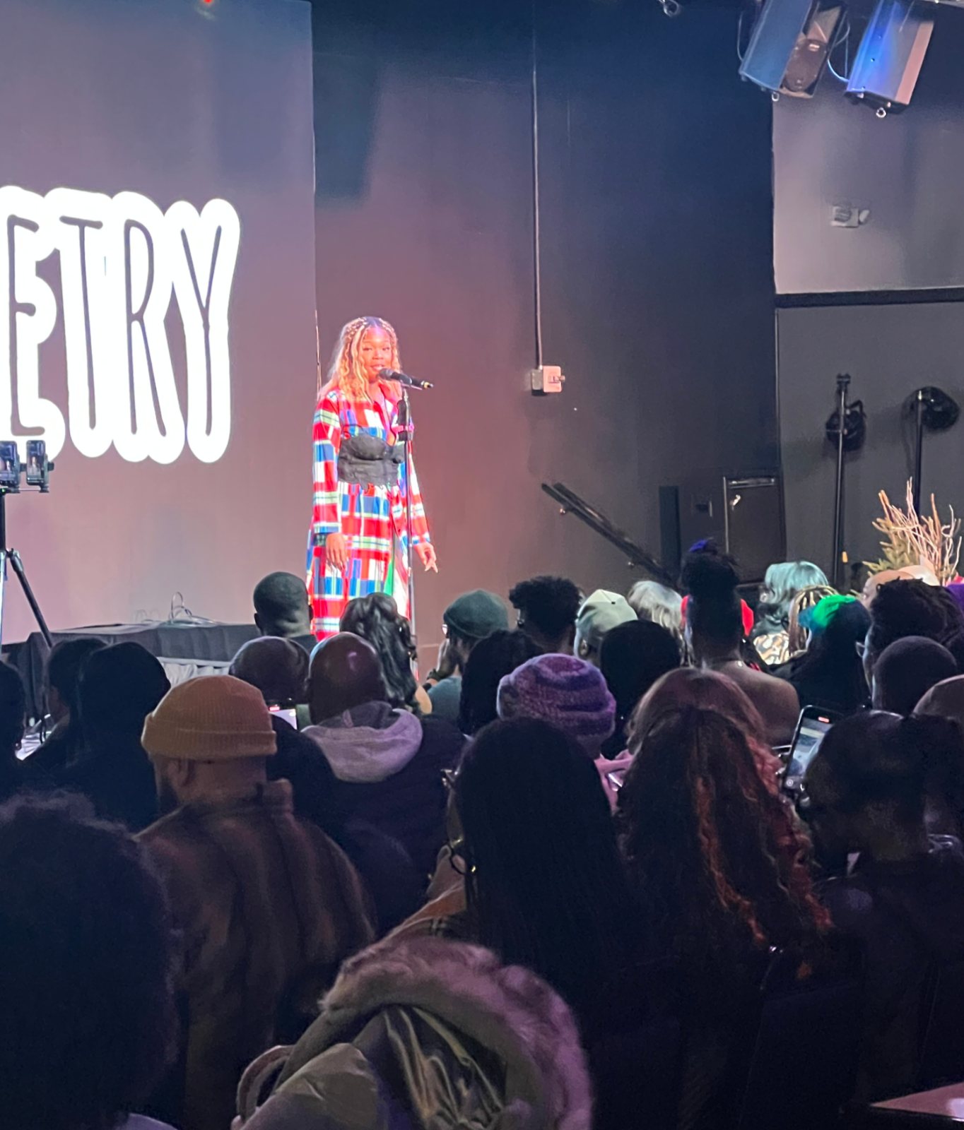 A spoken word performance in front of a packed house at La Familia
