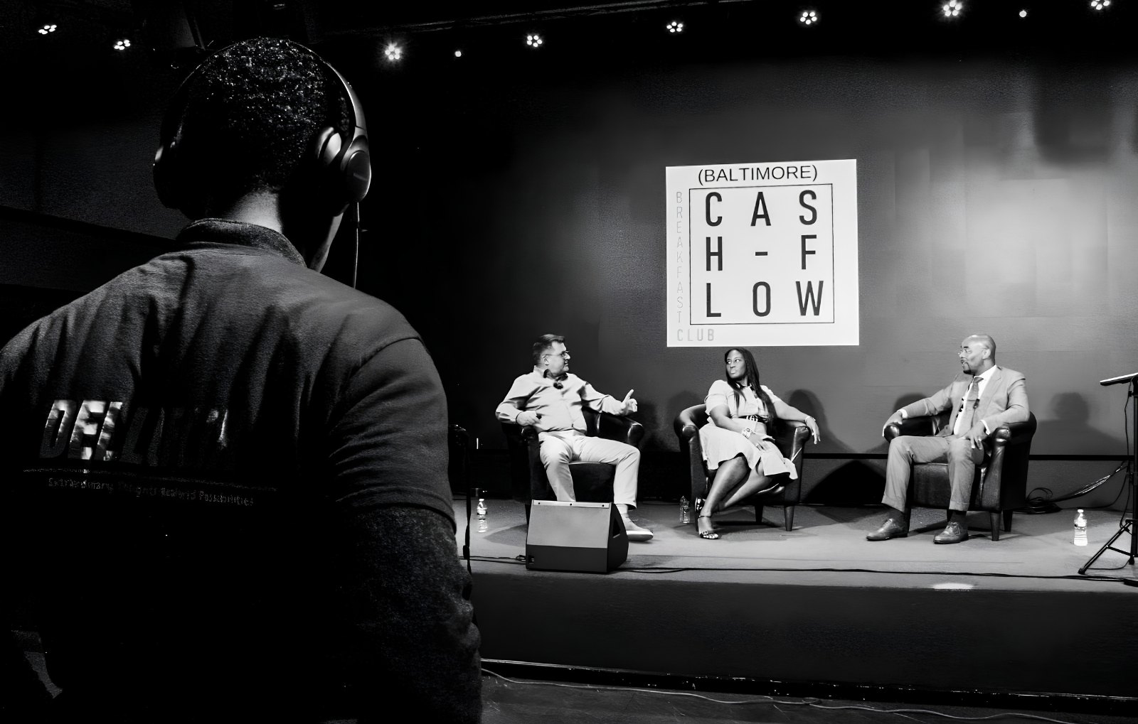 A panel recorded on the La Familia stage, with a production crew member monitoring audio