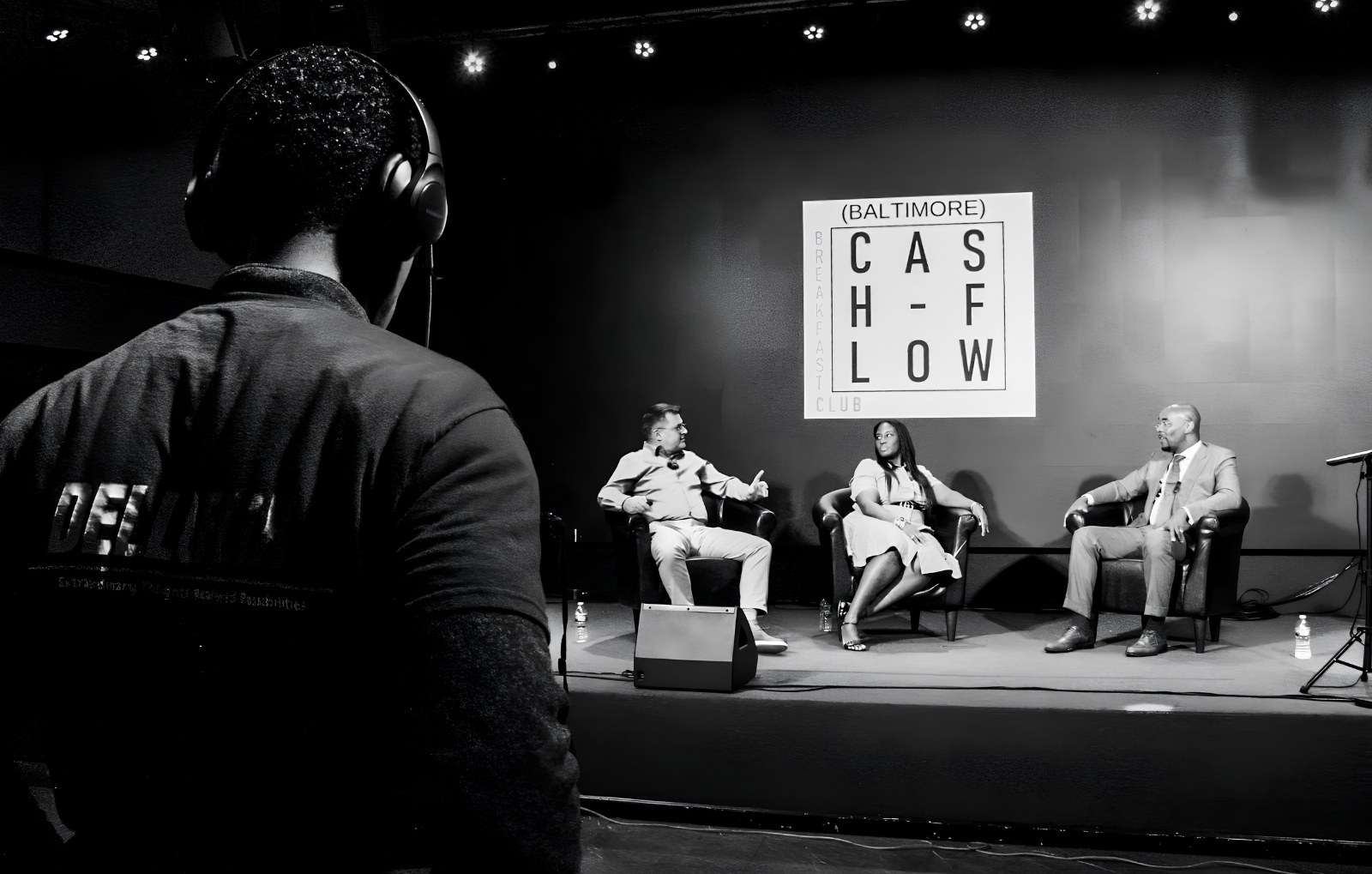 Production crew monitoring a live panel recording on the La Familia stage